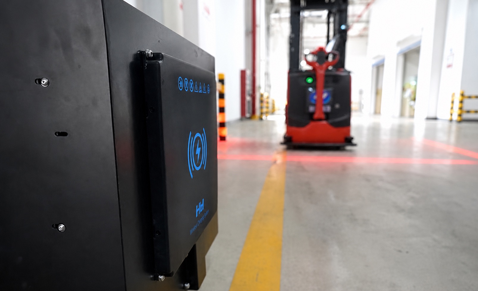 Wireless charging pad in an industrial facility with a vehicle in the background